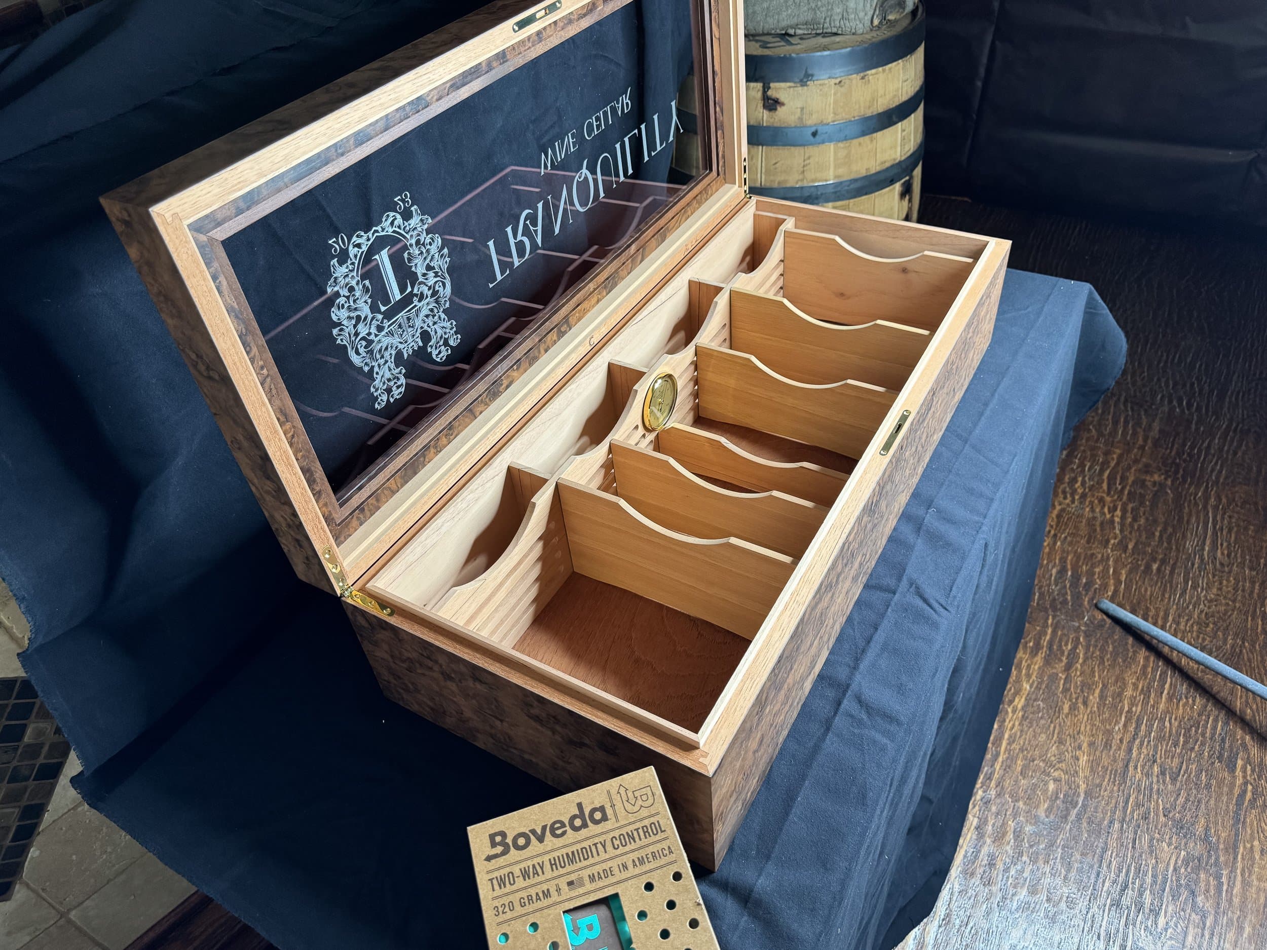 Open walnut burl humidor showing the Boveda carrier