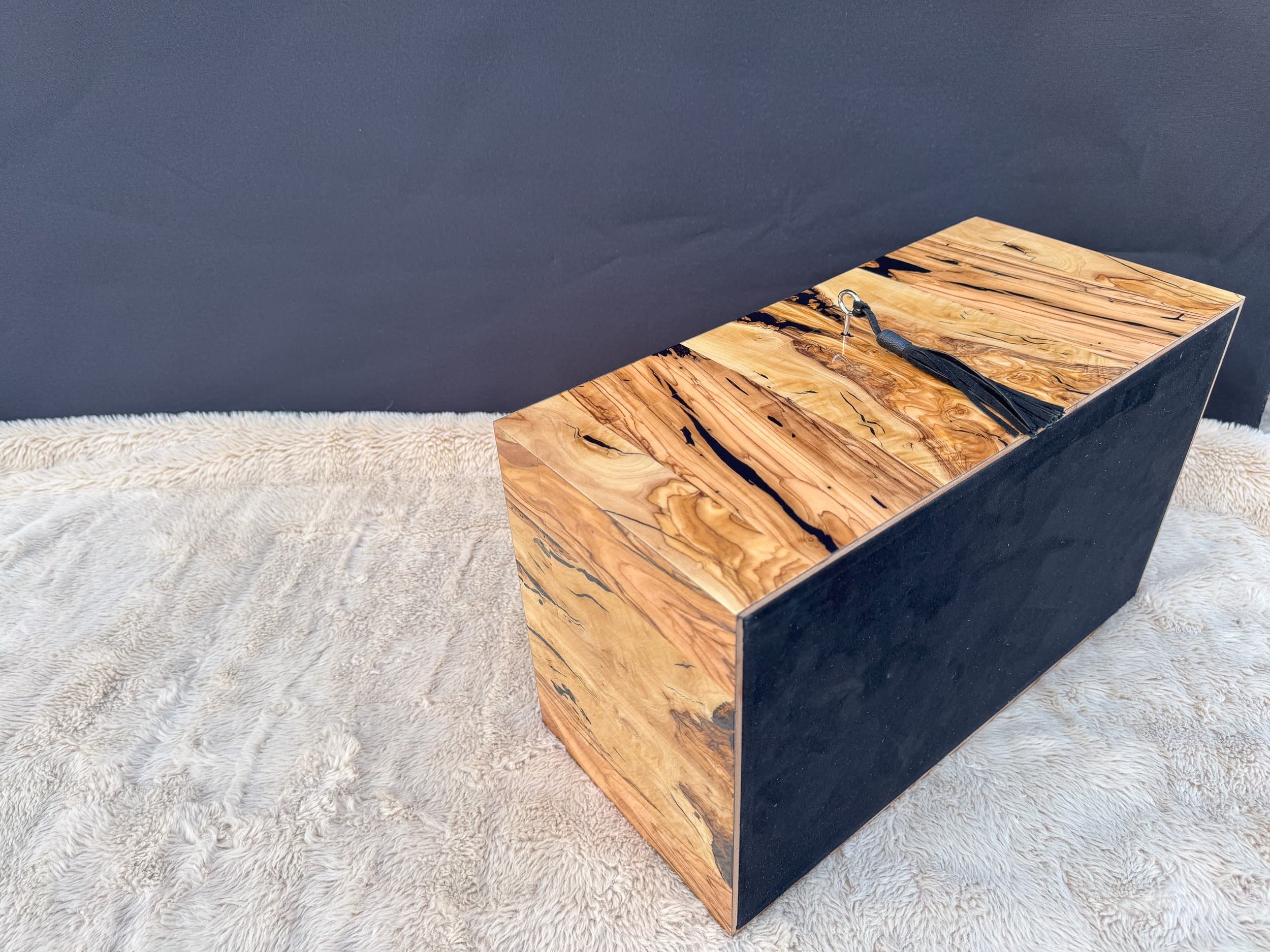 The Bethlehem: centient luxury bethlehem olivewood humidor black goat suede base angle view