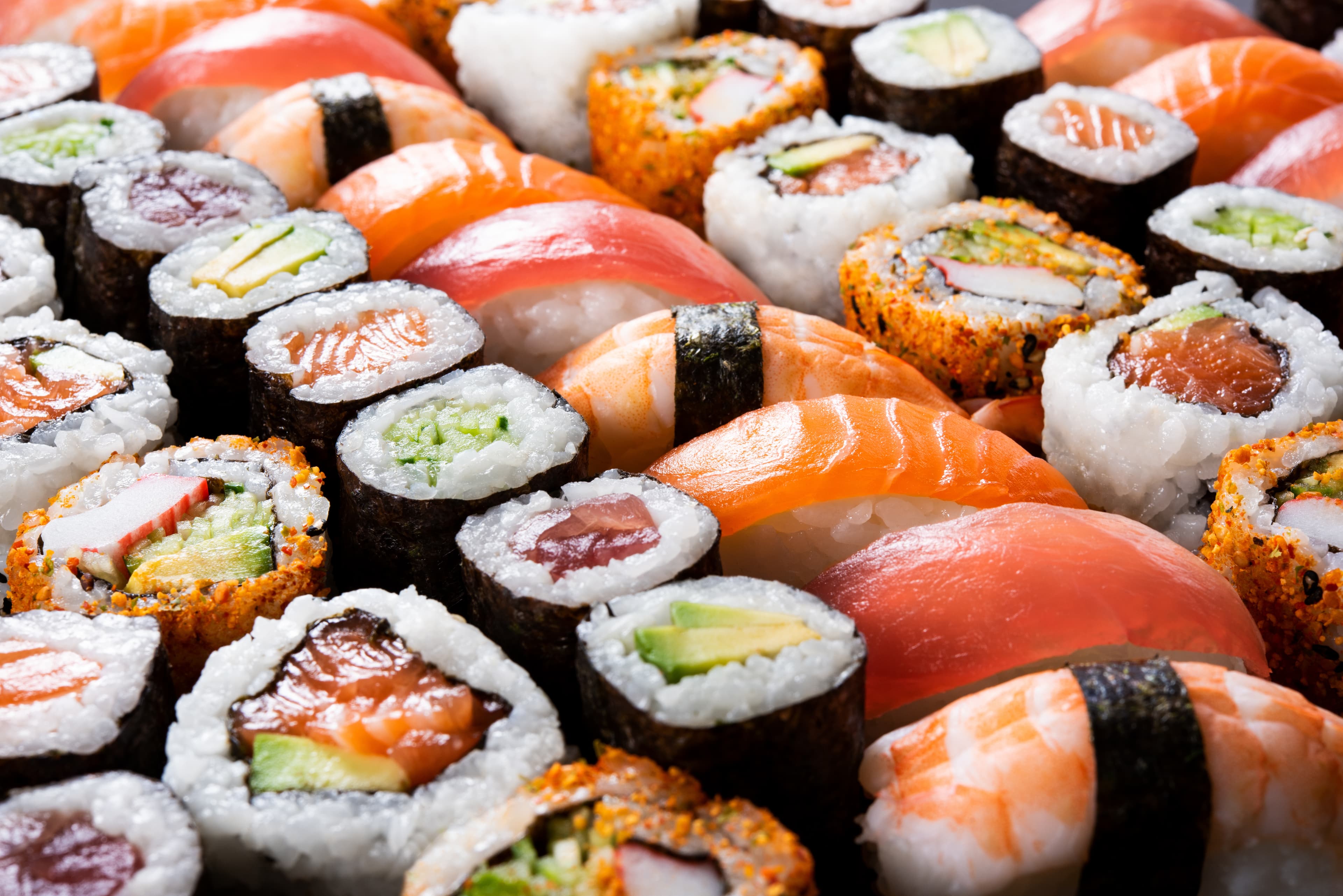 A dense platter of salmon and tuna nigiri with maki and uramaki.